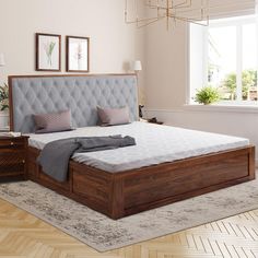 a large bed sitting on top of a hard wood floor next to a dresser and lamp