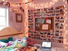 a bedroom decorated in pink and white with pictures on the wall, lights strung over the bed