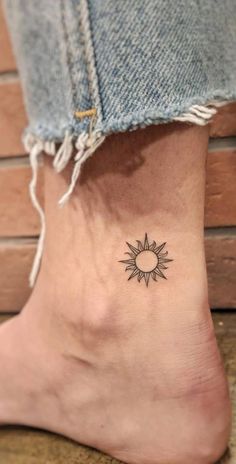 a small sun tattoo on the ankle