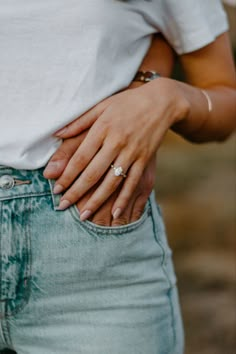 a woman in white shirt and jeans holding her stomach