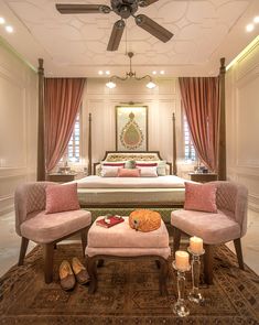 a bed room with a neatly made bed and two chairs sitting in front of it