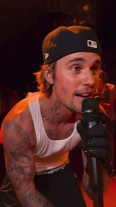 a man with tattoos on his arm holding a microphone