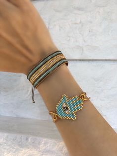 a woman's arm with two bracelets and an evil eye charm on it