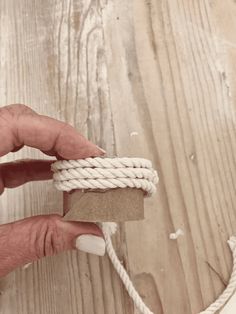 a person tying a rope on top of a wooden table