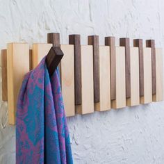 the coat rack is made out of wood and has a tie hanging from it's side