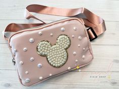 Beautiful Cross Body bag perfect for going to the theme parks or everyday use!  Attached are iridescent pearls and a mouse patch to match.  Bag itself is a buttery smooth beautiful soft dusty pink, dimensions are 6 in tall, 8.5 inches long and 2 inches in depth. The strap itself extends to up to 49.6 inches, perfect for plus size babes! The adjustable strap is a very soft and comfortable nylon and will not dig into your shoulders.  Behind the bag is a zipper pouch, perfect for your phone. Inside the main compartment is one mesh pouch and one that is spit into two. *Please message me to inquire about large orders! Mouse Bags, Disney Loungefly, Mickey Balloons, Disney Charms, Minnie Mouse Bow, Iridescent Pearl, Loungefly Bag, Disney Handbags, Pink Crossbody Bag