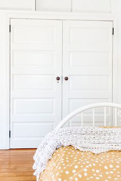 a white bed sitting next to two closet doors