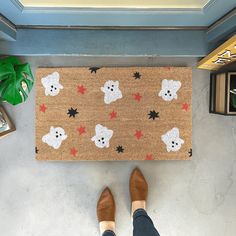 a person standing in front of a door mat with teddy bears on it and stars