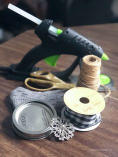 a pair of scissors, spools of thread and some other items on a table