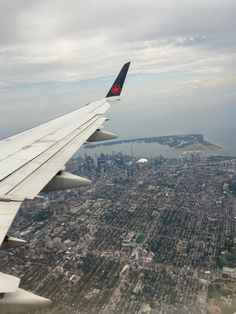 the wing of an airplane flying over a city