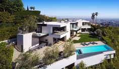 an aerial view of a house with a pool in the foreground