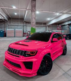 a bright pink jeep parked in a garage