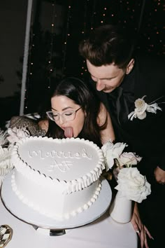 a man and woman standing in front of a cake