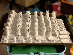 a close up of a plastic chess set on a tray with other pieces in the background