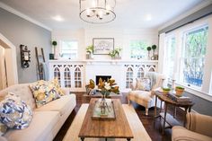 a living room filled with furniture and a fire place in the middle of a room