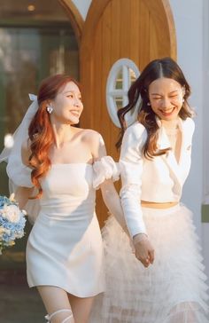 two young women dressed in white are walking together