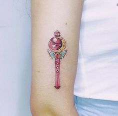 a woman's arm with a tattoo on it that has an arrow and ball