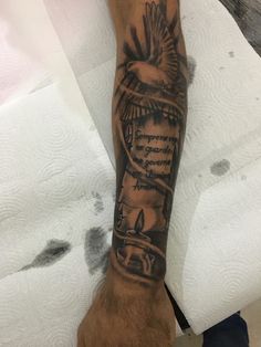 a man's arm with a bird on it and some words in the background