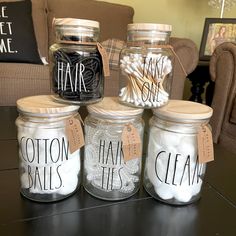 four jars with labels that say hair, cotton balls, and handmade soaps