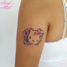 a hello kitty tattoo on the left upper arm and right lower arm, with a pink bow around its neck