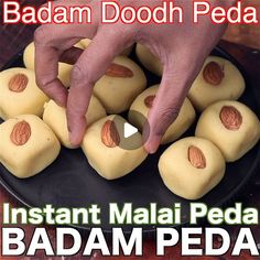 someone is placing almonds on top of some food in a black plate with the caption instant malai peda