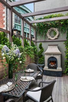 an outdoor dining area with table, chairs and fireplace