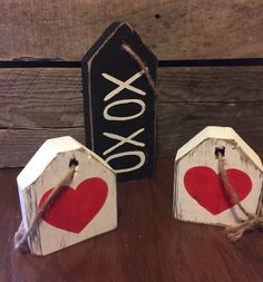 two small wooden boxes with red hearts on them sitting next to a sign that says xoxo