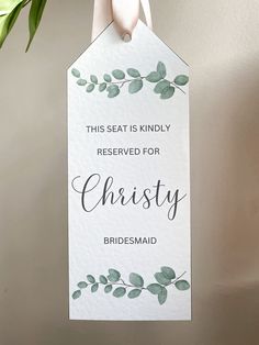 this seat is kindly reserved for bridesmaid sign hanging on the wall in front of a potted plant