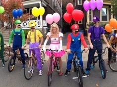 a group of people on bikes with balloons in the shape of heart shaped shapes and clowns