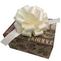 a large white flower sitting on top of a book with a ribbon around it's center