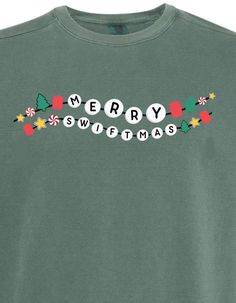 a green t - shirt that says merry with christmas decorations on the chest and letters across the chest