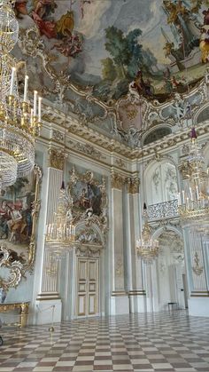 an ornate room with chandeliers and paintings on the walls