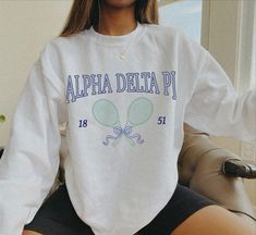 adpi is always the perfect match <3 ♡ Super soft sweatshirt comes in unisex sizing! Reference the size chart for additional details. It is recommended to SIZE UP for an oversized fit   ♡ Sweatshirt comes in white with a navy, blue and green print. Please check listing photos for color reference! ♡ Please make sure you are ordering for the correct sorority before placing an order! This listing is for ALPHA DELTA PI. We are unable to accept returns or exchanges for this since all items are made to order.   ♡ INSTRUCTIONS FOR CARE:  1. Turn inside out before washing  2. Wash on a gentle cycle  3. Recommended not heat dry to prevent any minimal shrinking, hang to dry instead ♡ It is important that you LOVE your product! If you have any questions or concerns upon receiving your product, please Alpha Delta Pi Shirts, Sorority Sweatshirt With Letter Print In Relaxed Fit, Sorority Letter Print Sweatshirt In Relaxed Fit, Cotton Sorority Sweatshirt With Graphic Print, Cotton Sweatshirt With Graphic Print For Sorority, Sorority Long Sleeve Graphic Sweatshirt, Sorority Graphic Print Long Sleeve Sweatshirt, White Sorority Sweatshirt With Letter Print, White Sorority Crew Neck Sweatshirt