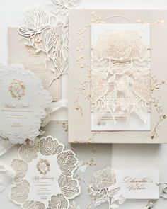 the wedding stationery is laid out on top of each other, with gold accents