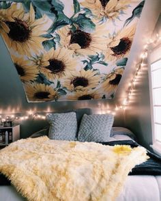 a bedroom with sunflowers painted on the ceiling and lights strung from the ceiling