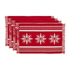 three red and white placemats with snowflakes on the front, one has fringe