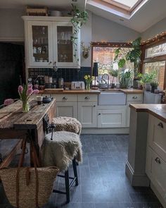 a kitchen filled with lots of counter top space and wooden stools under a skylight