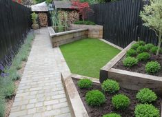 an outdoor garden with grass and plants in the center, next to a brick path