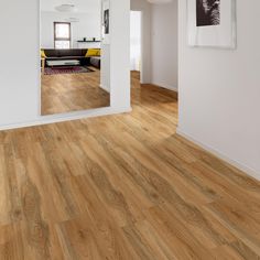 an empty room with hard wood floors and white walls is seen from the doorway to the living room