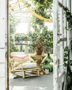 an open door leading to a patio area with furniture and potted plants on it