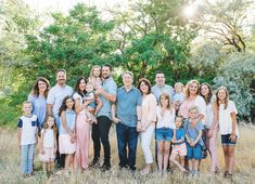 a large family is posing for a photo in the grass