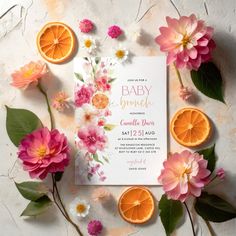 an orange and pink flower baby shower is surrounded by leaves, flowers, and fruit