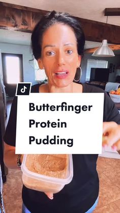 a woman holding up a sign that says butterfingerer protein pudding in front of her face