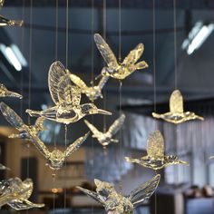 a group of glass birds hanging from strings