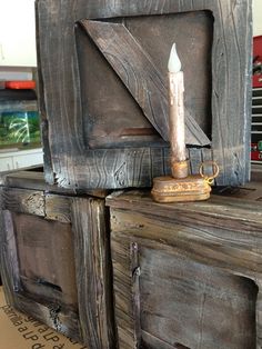 an old wooden cabinet with a candle in the middle and other items on top of it