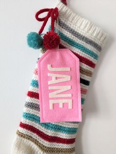 a striped sock with a pink name tag hanging from it