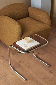 a chair with a book on it sitting next to a table