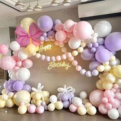 balloons are arranged in the shape of an arch for a happy birthday sign on display