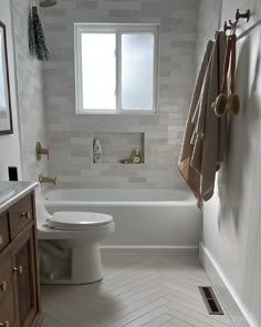 an instagram photo of a bathroom with white tile and wood accents on the walls