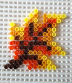 an orange, yellow and black star made out of legos on a white surface